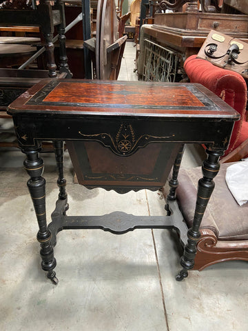 Victorian ebonised wood and amboyna sewing table on wheels with compartment storage.&nbsp;