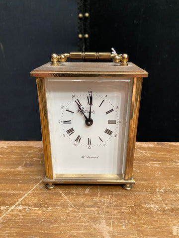 Vintage H. Samuel quartz carriage clock in shiny brass casing.