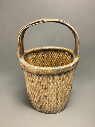 Chinese rice basket crafted from tightly woven willow with a bent bamboo handle. Circa early 20th century. We have a similar larger rice basket that has painted Chinese characters on the handle.