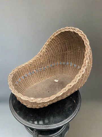 Antique rustic wicker baby basket in an aged condition.