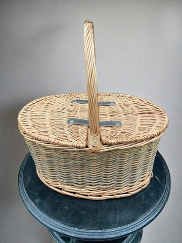 Traditional oval double-lidded picnic basket in sturdy condition.
