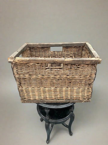 Rustic wicker wine bottle carrier in an aged condition.