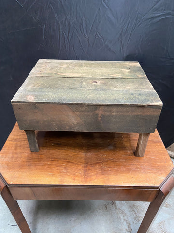 Rustic low wooden stool in an aged condition. 
