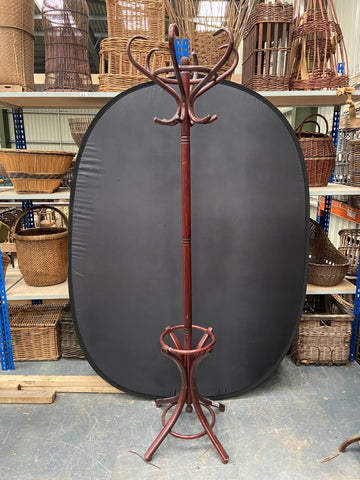 Large wooden bentwood hat stand with a maroon stain and glossy finish. 