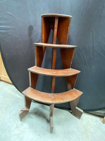 Half-round wooden plant stand with four tiers.