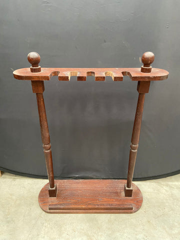 Long wooden umbrella or walking stick stand in an aged condition.