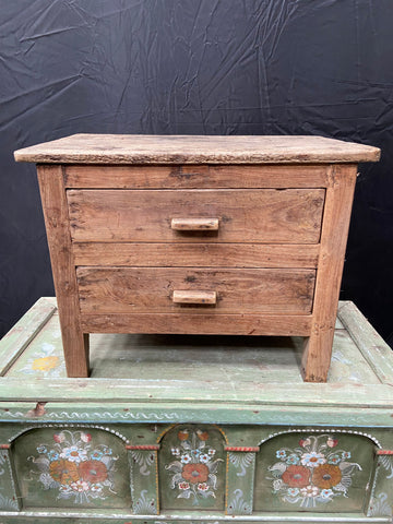 Rustic low bedside table with two drawers.
