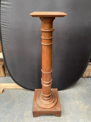 Victorian light wooden torchiere pedestal stand with a thick stem.