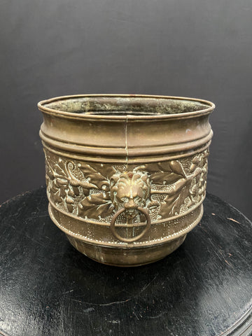 A pair of early 20th-century brass jardinieres planters with a decorative embossed design featuring a lion head.&nbsp;&nbsp;