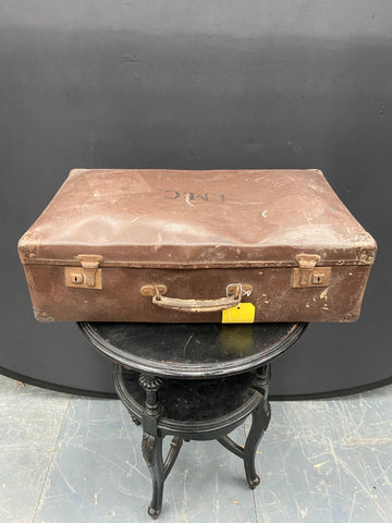 Vintage brown metal dented suitcase with the initials JMC stamped on the lid.&nbsp;