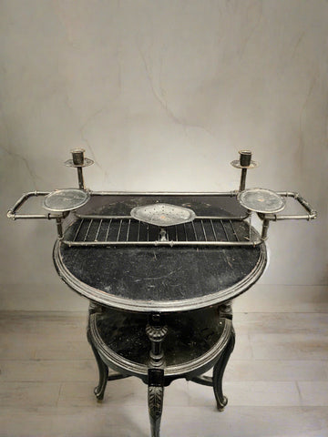 Unusual antique black bath tray with a soap dish, two round surfaces, and double candle holders.
