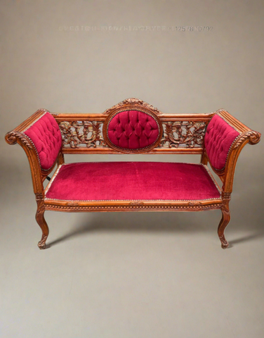 A Victorian-style carved mahogany setee with crimson pink upholstery.