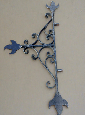 Large symmetrical wrought iron bracket,&nbsp;with floral motifs.
