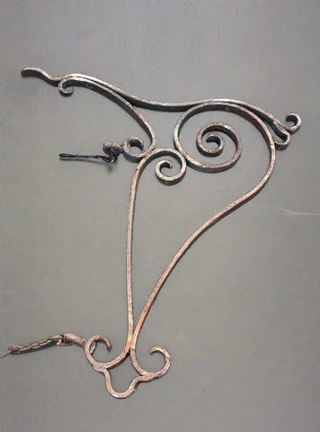 Unusual curved bracket for sign hanging in an aged condition.