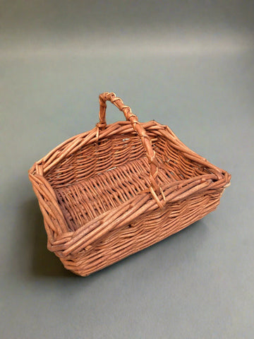 Square stained wicker basket with a criss cross handle.
