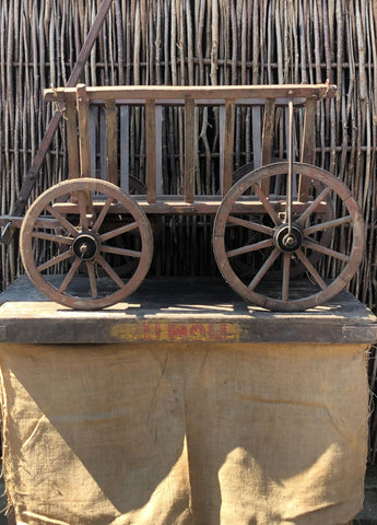 Antique rustic wooden hay cart with crossbar handle and slatted wood detailing.