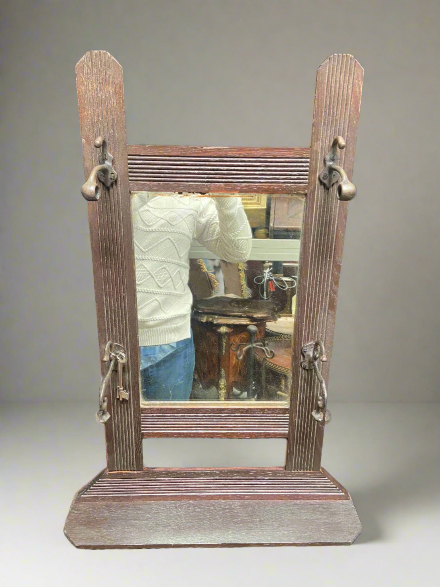 Simple wooden rectangular mirror with four pegs and a single shelf.