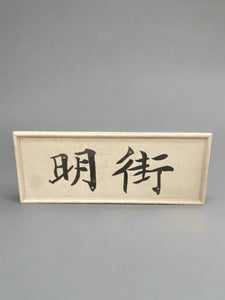 Black and white painted Chinese signage on a simple wooden backboard.