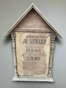 London Borough Police £50 reward poster sitting in a wooden frame.