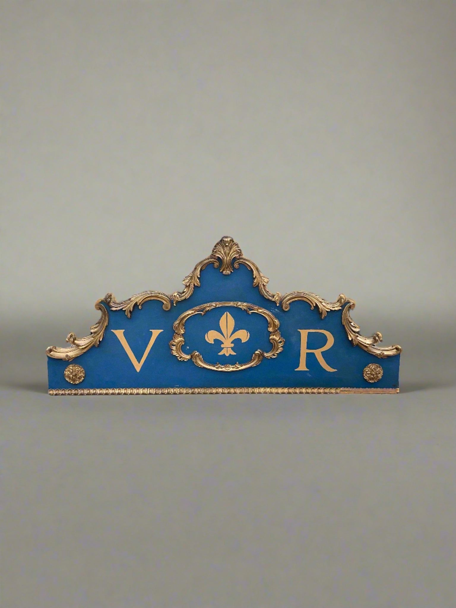 Royal Victorian blue and gold prop make sign with ornate scroll detailing. VR likely standing for Victoria Regina.