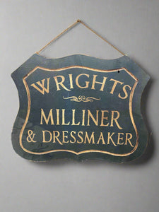 'Wrights Milliner & Dressmaker' sign, stenciled onto a cut wooden backboard Film TV Props