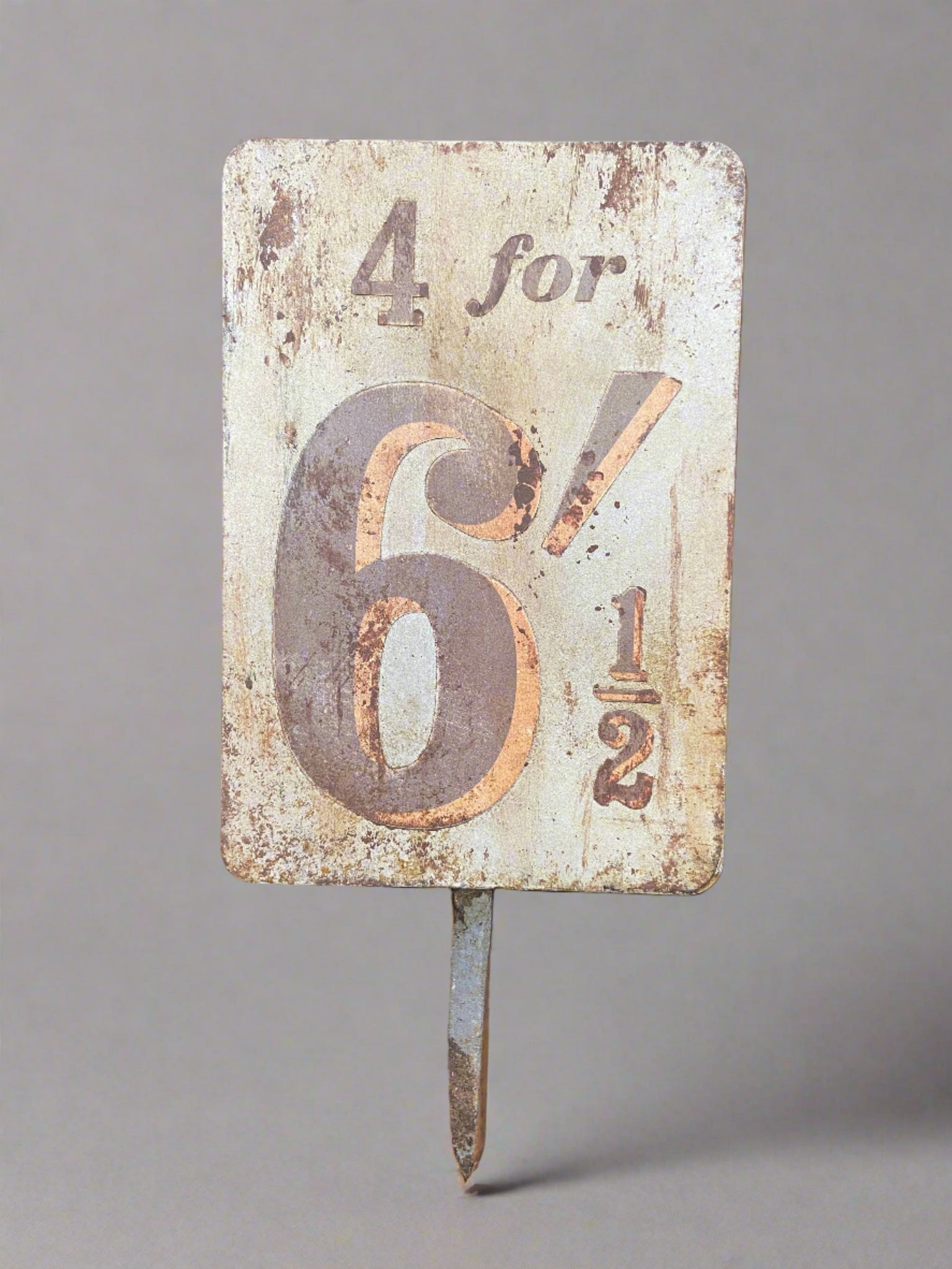 Vintage metal pricing sign in an aged condition.