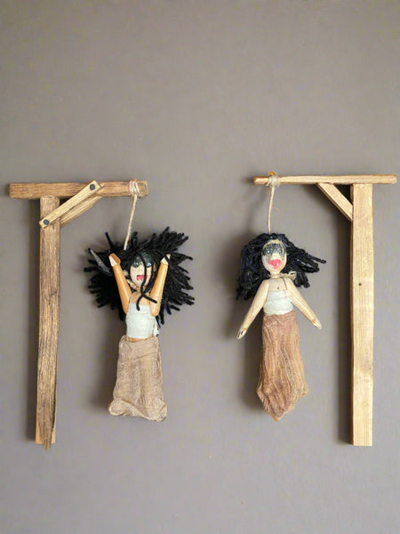 An unusual prop make of a wooden frame which is to be worn by tieing the fabric straps around the actors waist. The frame is dressed with creepy hanging voodoo dolls.