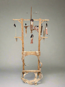 An unusual prop make of a wooden frame which is to be worn by tieing the fabric straps around the actors waist. The frame is dressed with creepy hanging voodoo dolls.