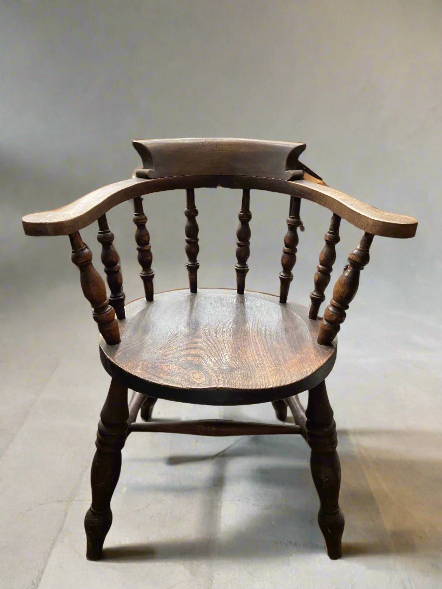 A Victorian elm and beech smoker's bow elbow chair-with eight-turned spindles and low back support. Perfect dressing for a period study or library.