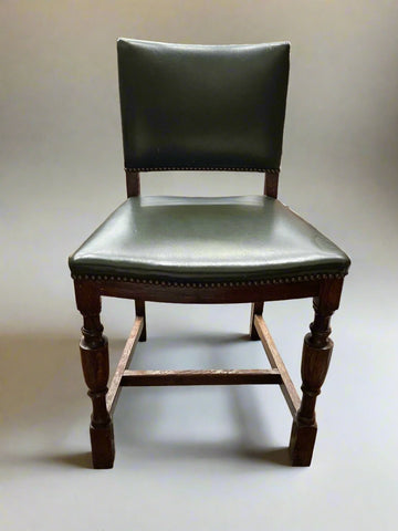 A set of pub dining chairs upholstered in green studded leather.