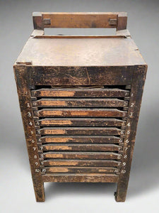 Antique wooden printer's drawers with sectioned drawers for printing type blocks.
