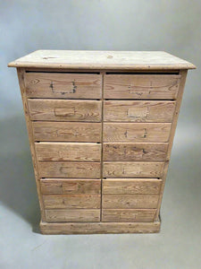 Sixteen-drawer pine unit with missing handles/labels.