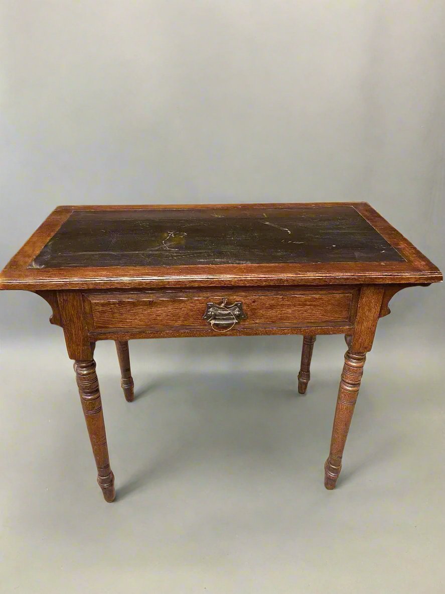 Small antique writing desk with a single drawer and turned legs.