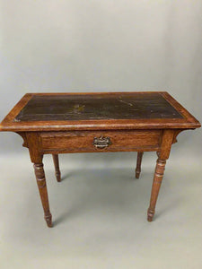 Small antique writing desk with a single drawer and turned legs.