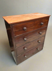 Simple wooden four-drawer bedroom dresser with round knob handles.