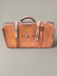 H.F.T. initialled leather suitcase in a vintage style.