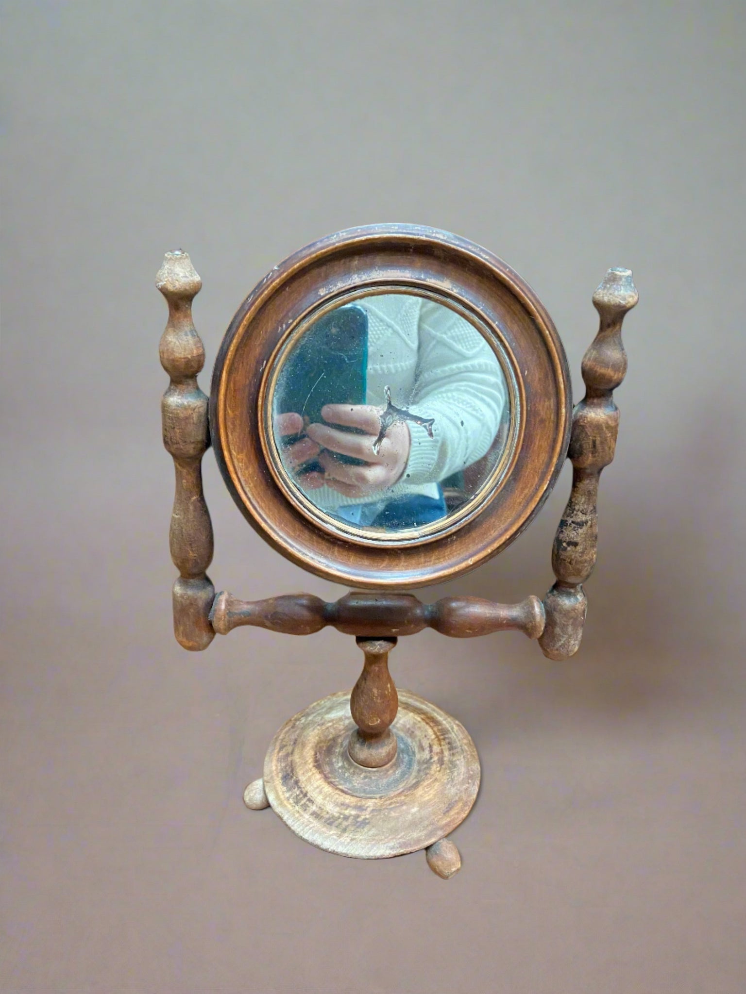 19th Century British table mirror which sits in a turned wooden frame with three angled bun feet.