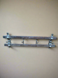 Wall-mounted coat rack comprising two horizontal bars and four metal hooks.