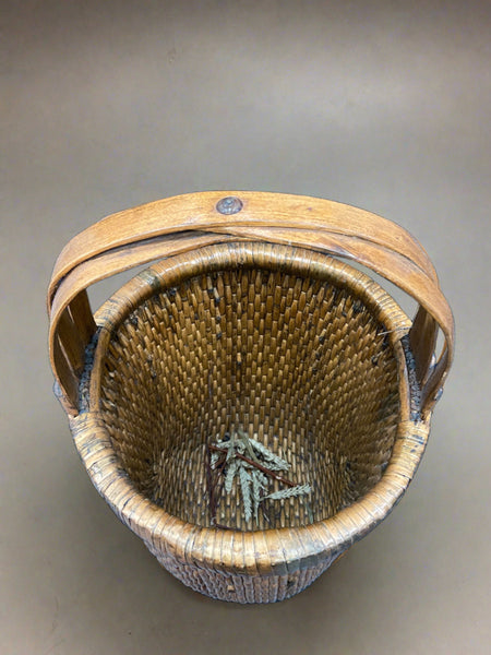 Chinese rice basket crafted from tightly woven willow with a bent bamboo handle. Circa early 20th century. We have a similar larger rice basket that has painted Chinese characters on the handle.