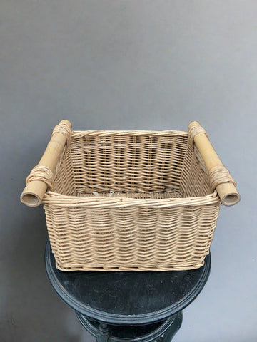 Medium-sized wicker basket with hollow wooden roller handles.
