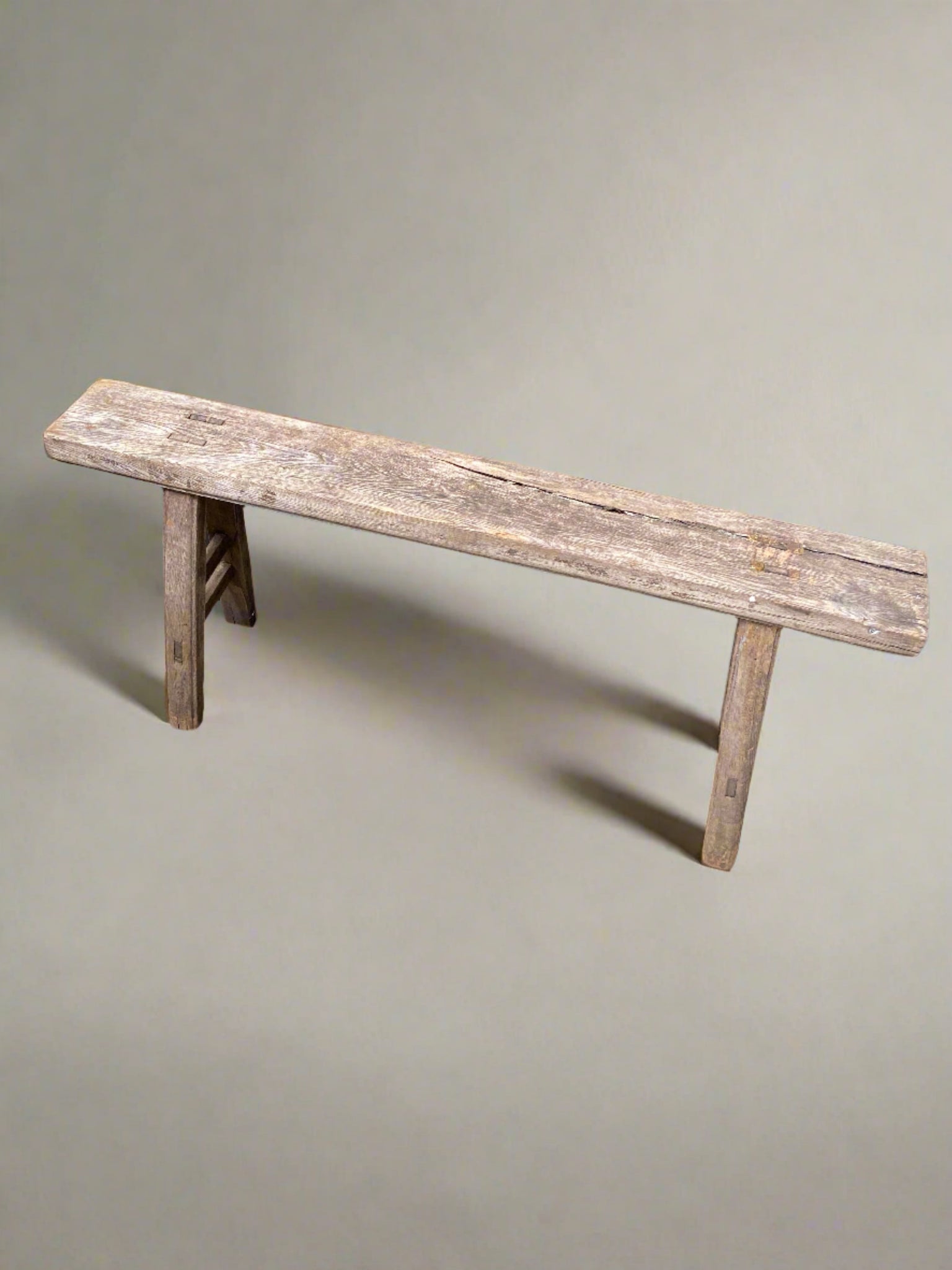 Small rustic pig bench with traditional construction joints and A-frame legs.