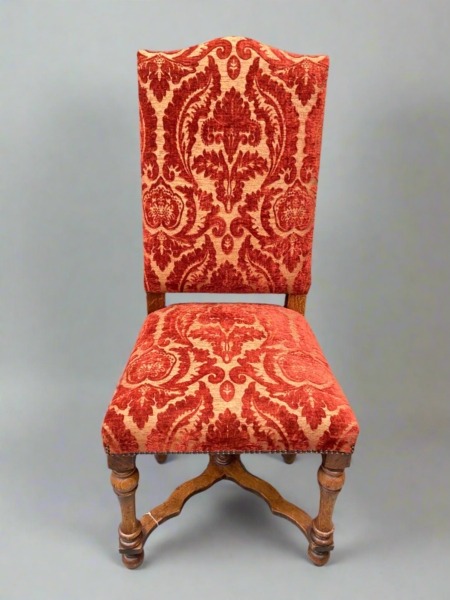 A set of French dining chairs upholstered in crimson Giada 5 fabric.