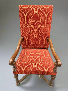 A large crimson French dining chair with wooden supportive arms, which matches a full dining set without arms.