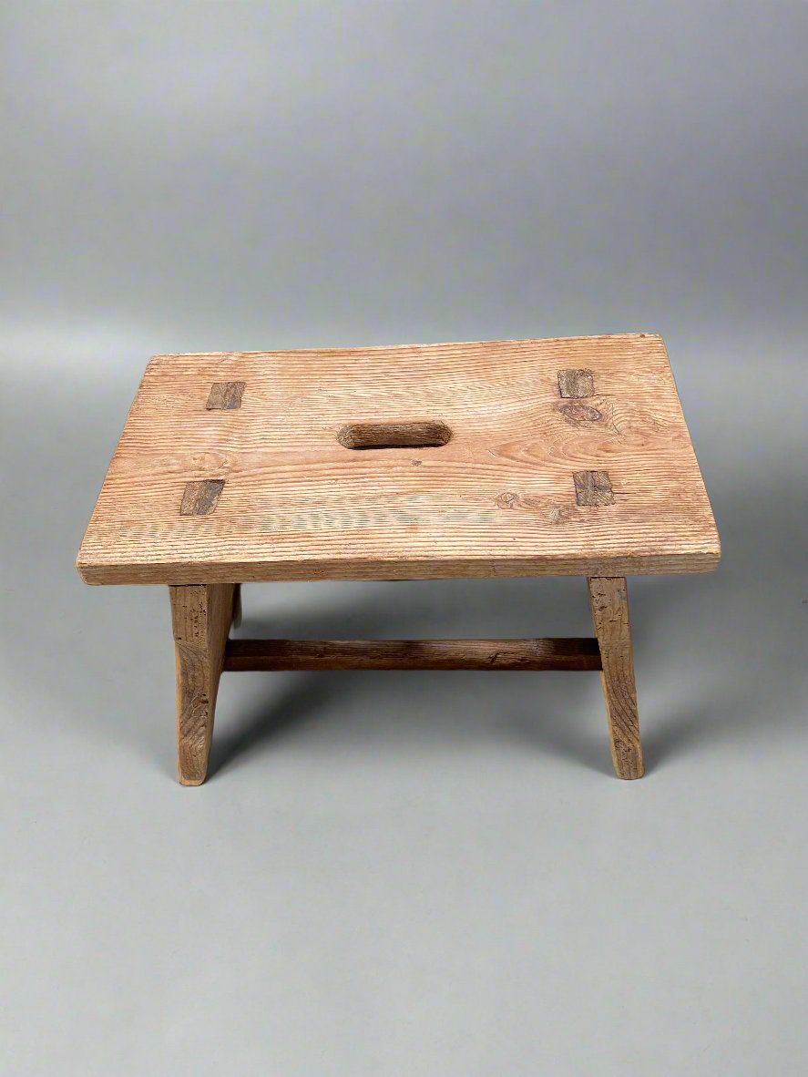 Primitive wooden scratch-built footstool with an oblong-shaped carry hole. Looks to be made from pitch pine.