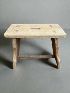 Rustic wooden scratch-built farm stool with an oblong-shaped carry hole.