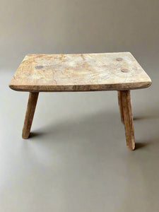 Rustic three-legged milking stool. 