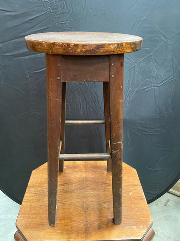 Tall wooden barstool with a circular seat.