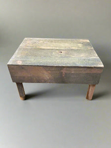 Rustic low wooden stool in an aged condition. 