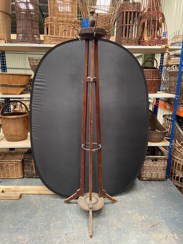 Antique wooden hat stand with three thick wooden supports and a central drip tray for umbrellas. 