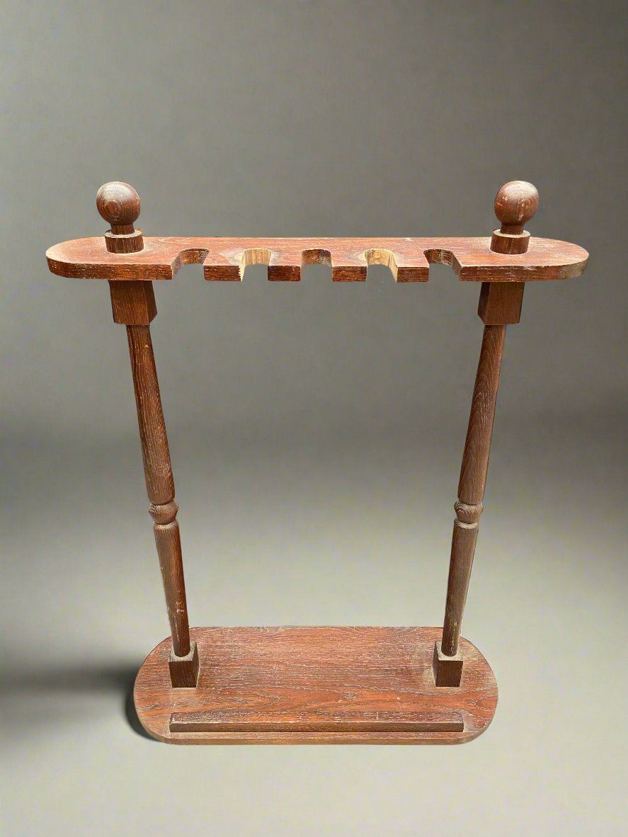 Long wooden umbrella or walking stick stand in an aged condition.